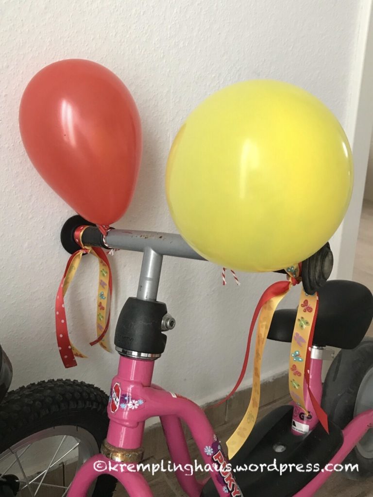 roter und gelber Luftballon am Lenker