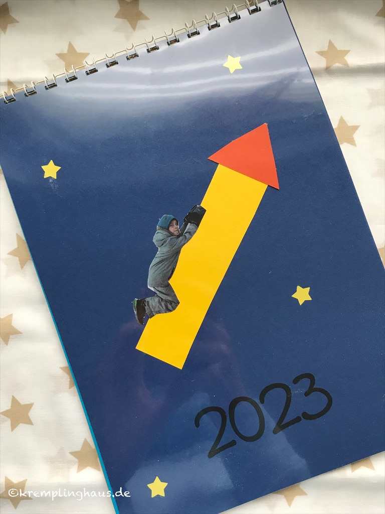 Kalender 2023 dunkelblaues Deckblatt mit gelber Rakete und Sternen