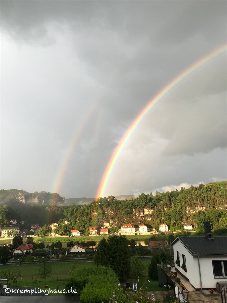 Blick auf das Dorf Rathen in der Sächsischen Schweiz mit 2 Regenbögen am Himmel